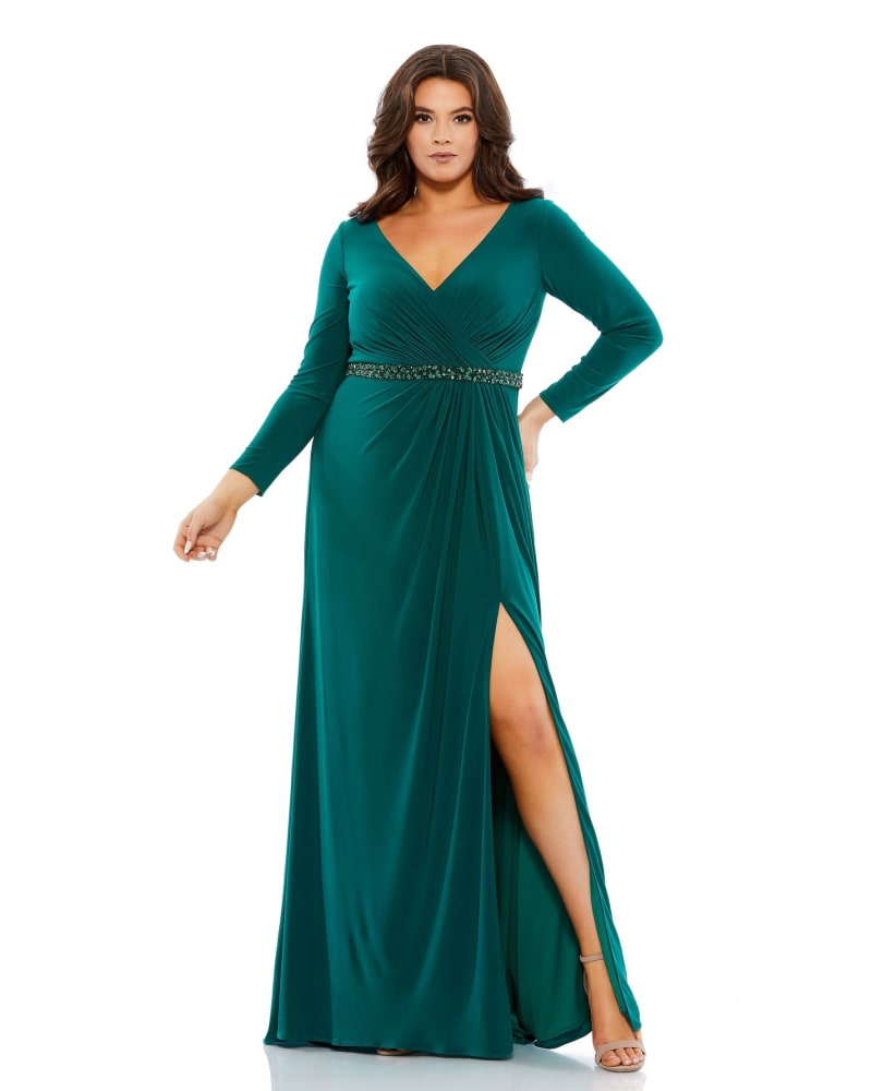 Front of a model wearing a size 14W Beaded Belt Jersey Faux Wrap Long Sleeve Gown in Emerald by Mac Duggal. | dia_product_style_image_id:289852